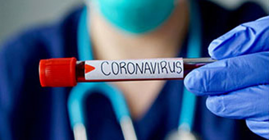 Medical professional holding a vial labelled 'coronavirus'