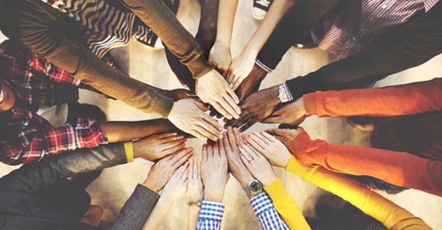 Group of people putting their hands together 