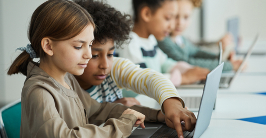 A classroom with children using laptops