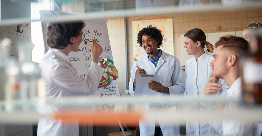 Group of students and an educator working in a science lab