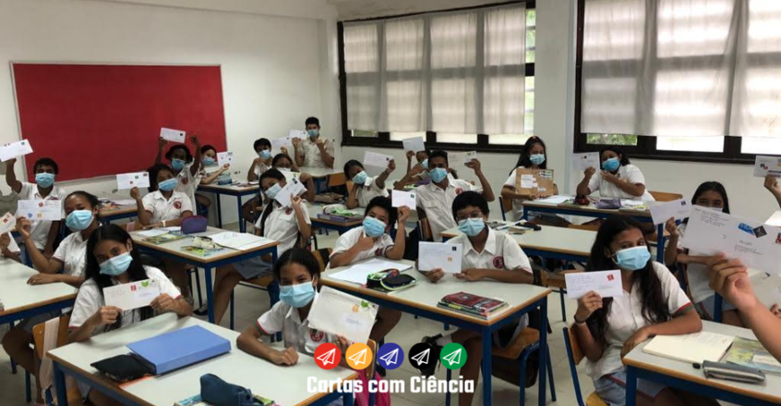 Students in a classroom holding up letters