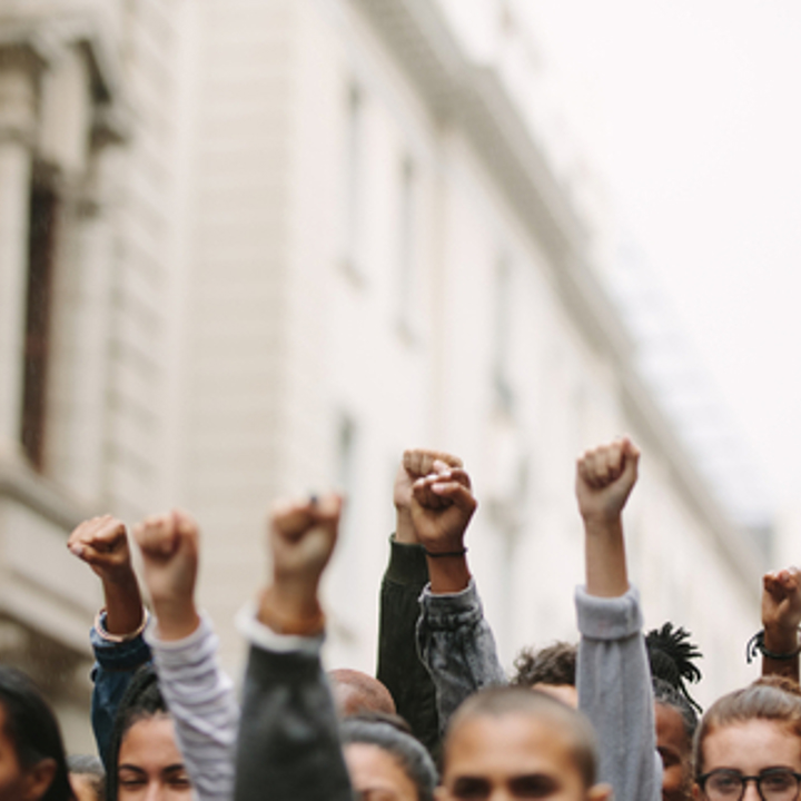 Photo of people with hands up in unity